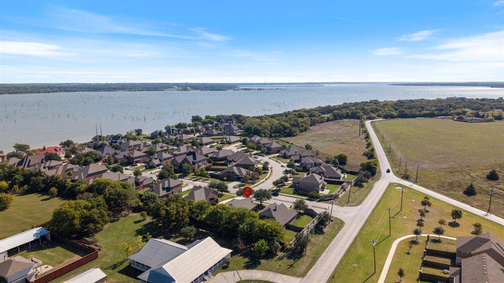 1802 Watermark Lane, Wylie, TX 75098 Aerial perspective of residential property situated in a waterfront community featuring mature trees, expansive open land, and proximity to a large reservoir