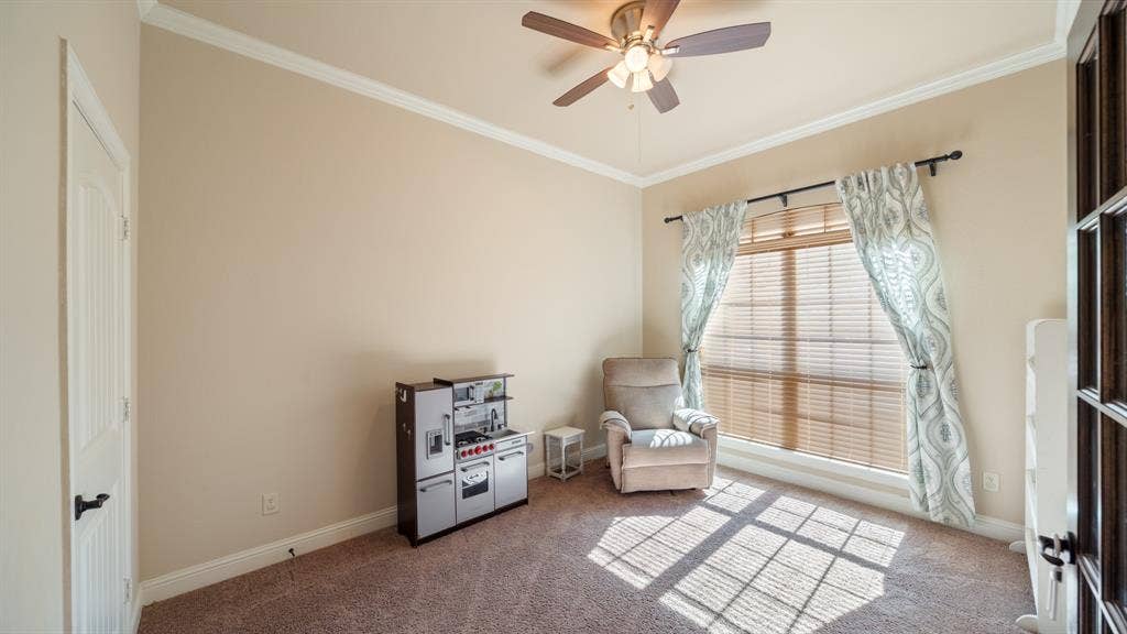 1802 Watermark Lane, Wylie, TX 75098 Room featuring neutral paint, wall-to-wall carpeting, ceiling fan with light kit, crown molding, and a single-pane window with blinds