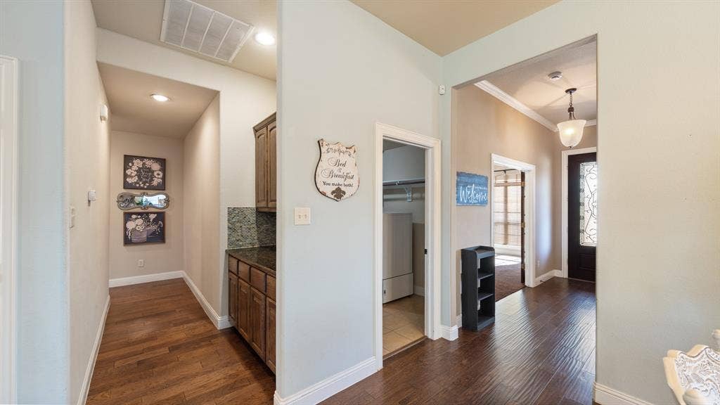 1802 Watermark Lane, Wylie, TX 75098 Wood-finish flooring, built-in cabinetry with stone-surface countertop, recessed lighting, and a glass-paneled entry door