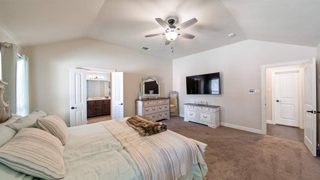 1802 Watermark Lane, Wylie, TX 75098 Vaulted ceiling featuring a central multi-blade ceiling fan, wall-to-wall carpeting, and neutral interior wall paint