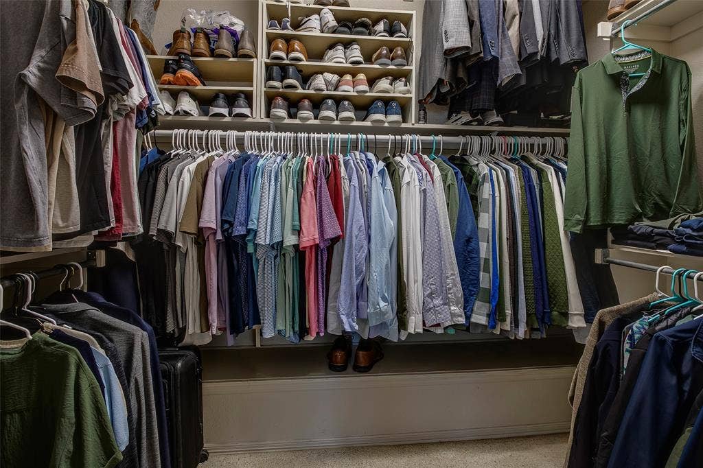 Custom closet system featuring multiple hanging rods, integrated shelving, and shoe storage