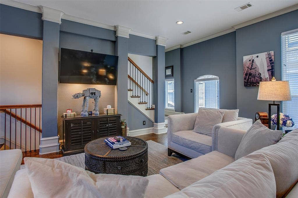 Living area featuring hardwood flooring, a built-in entertainment niche, white crown molding, and abundant natural light from multiple windows