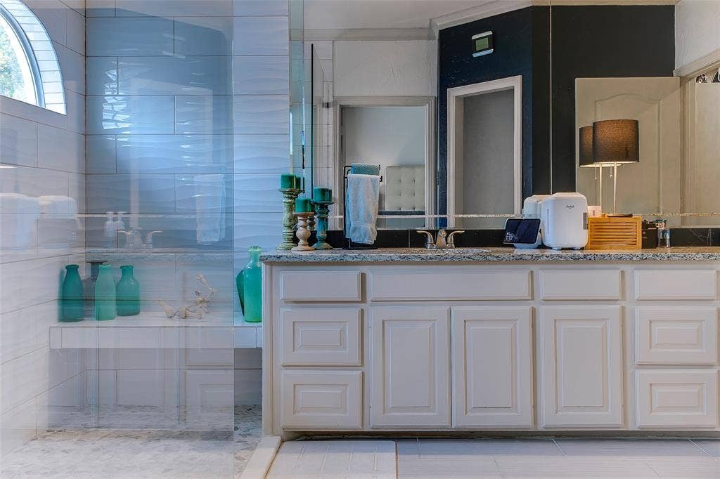 Bathroom featuring a white vanity with panel cabinetry and a speckled countertop