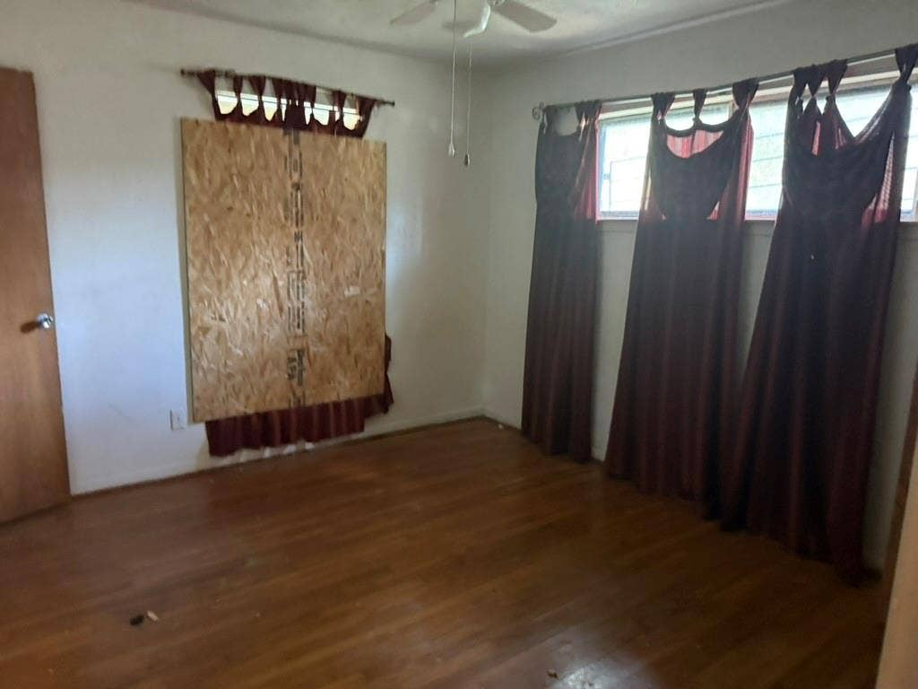 Wood-finish flooring, multi-pane windows, and a ceiling-mounted fan