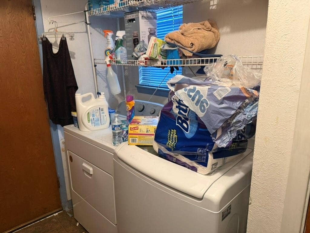 Laundry area featuring white top-load washer and dryer with wire shelving