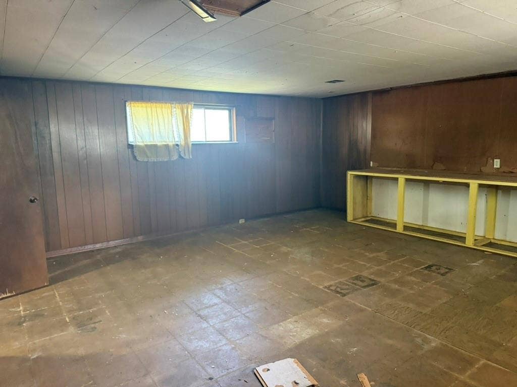 Interior space featuring paneled wood walls, paneled ceiling, and a built-in wooden frame workstation