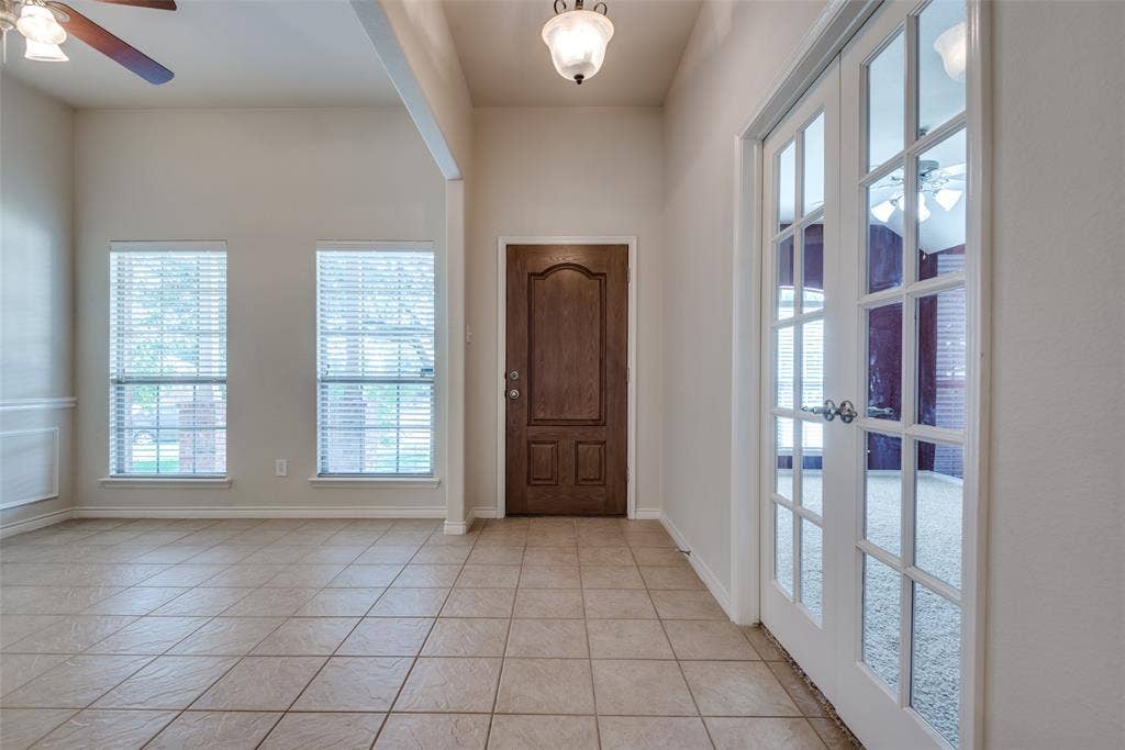 Entryway with light tile patterned floors, baseboards, and a ceiling fan