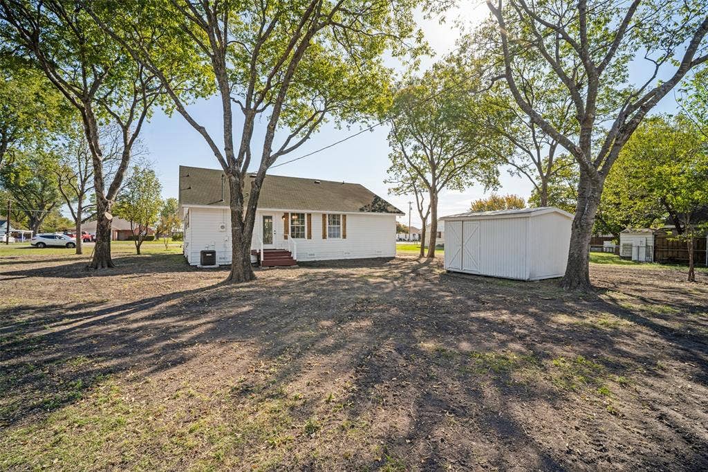 415 S Bell Street, Royse City, TX 75189 Expansive rear grounds featuring mature trees and a detached storage shed