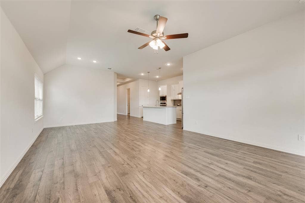 3934 Timberview Street, Midlothian, TX 76065 Open-concept interior featuring vaulted ceilings, wood-finish flooring, recessed lighting, and a ceiling fan