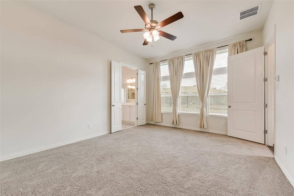 3934 Timberview Street, Midlothian, TX 76065 Interior space featuring plush carpeting, a multi-blade ceiling fan with integrated lighting, and expansive windows with transom panels