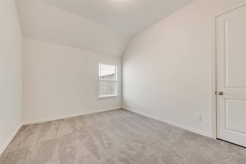 3934 Timberview Street, Midlothian, TX 76065 Neutral-toned carpeted flooring, vaulted ceiling, single-pane window with blinds, and a two-panel interior door