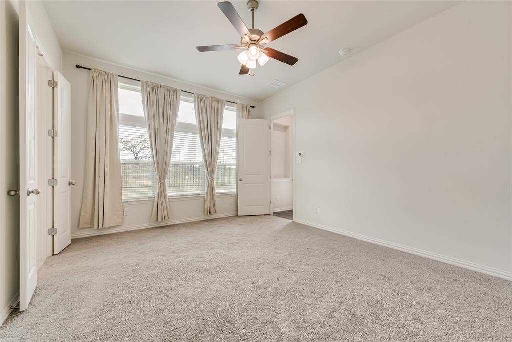 3934 Timberview Street, Midlothian, TX 76065 Neutral-toned wall-to-wall carpeting, three-panel oversized windows, and a multi-blade ceiling fan with integrated lighting