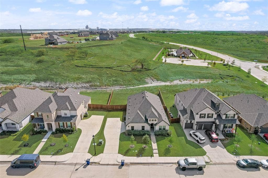 3934 Timberview Street, Midlothian, TX 76065 Aerial perspective of residential properties featuring concrete driveways, multi-pitched shingled roofs, masonry facades, and landscaped front lawns