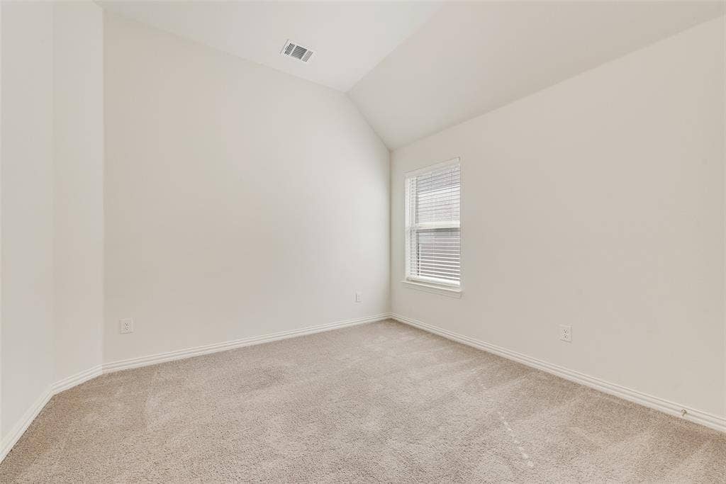 3934 Timberview Street, Midlothian, TX 76065 Neutral-toned room featuring a vaulted ceiling, wall-to-wall carpeting, and a single window with horizontal blinds