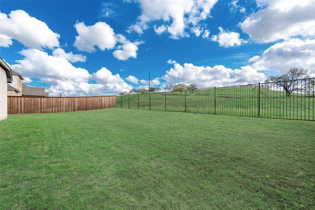 3934 Timberview Street, Midlothian, TX 76065 Expansive backyard featuring a level lawn, wood privacy fencing, and metal perimeter fencing