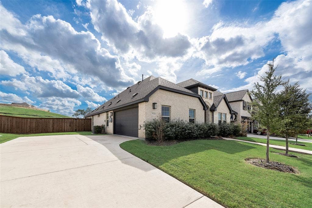 3934 Timberview Street, Midlothian, TX 76065 Brick exterior residence featuring a multi-gable roofline, attached multi-car garage, expansive concrete driveway, and professional landscaping