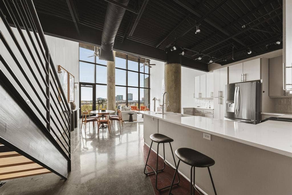 3110 Thomas Avenue, #717, Dallas, TX 75204 Industrial-style open concept living with exposed ductwork, a concrete structural column, and a black-painted ceiling