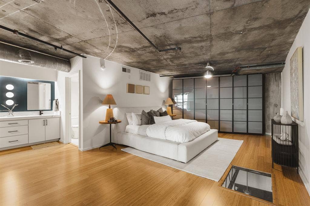 3110 Thomas Avenue, #717, Dallas, TX 75204 Concrete ceiling with exposed ductwork, wood-finish flooring, built-in wardrobe with frosted glass panels, vanity with white cabinetry and undermount sink, and recessed lighting