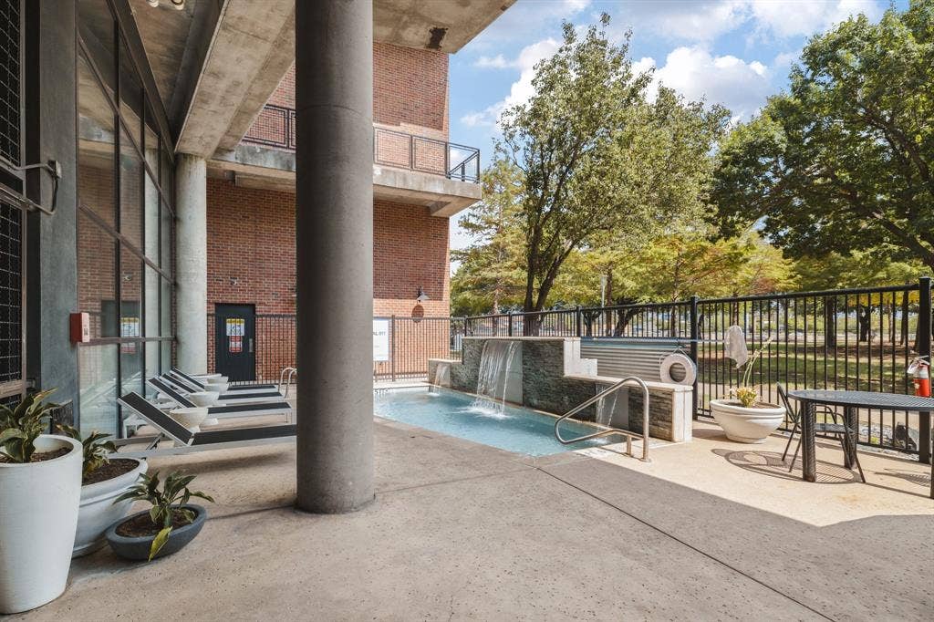 3110 Thomas Avenue, #717, Dallas, TX 75204 Outdoor aquatic feature with a waterfall, tile surround, and adjacent concrete patio