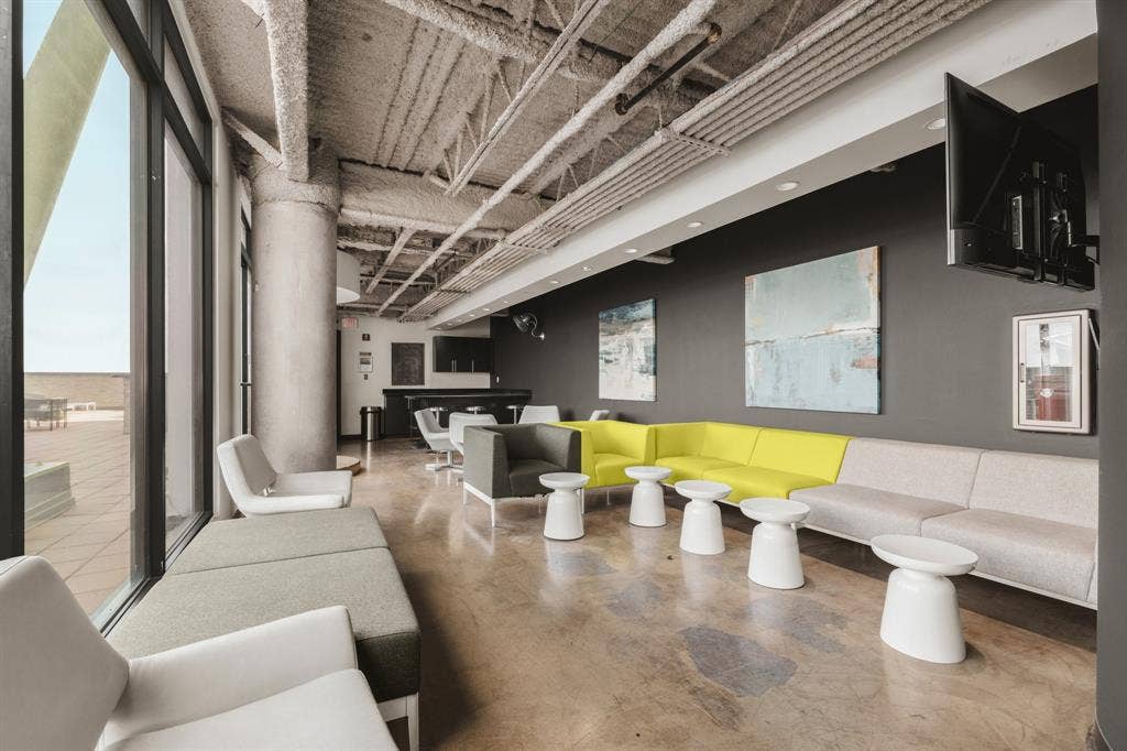 3110 Thomas Avenue, #717, Dallas, TX 75204 Expansive window line, exposed structural ceiling, polished concrete flooring, built-in bar area, and recessed lighting