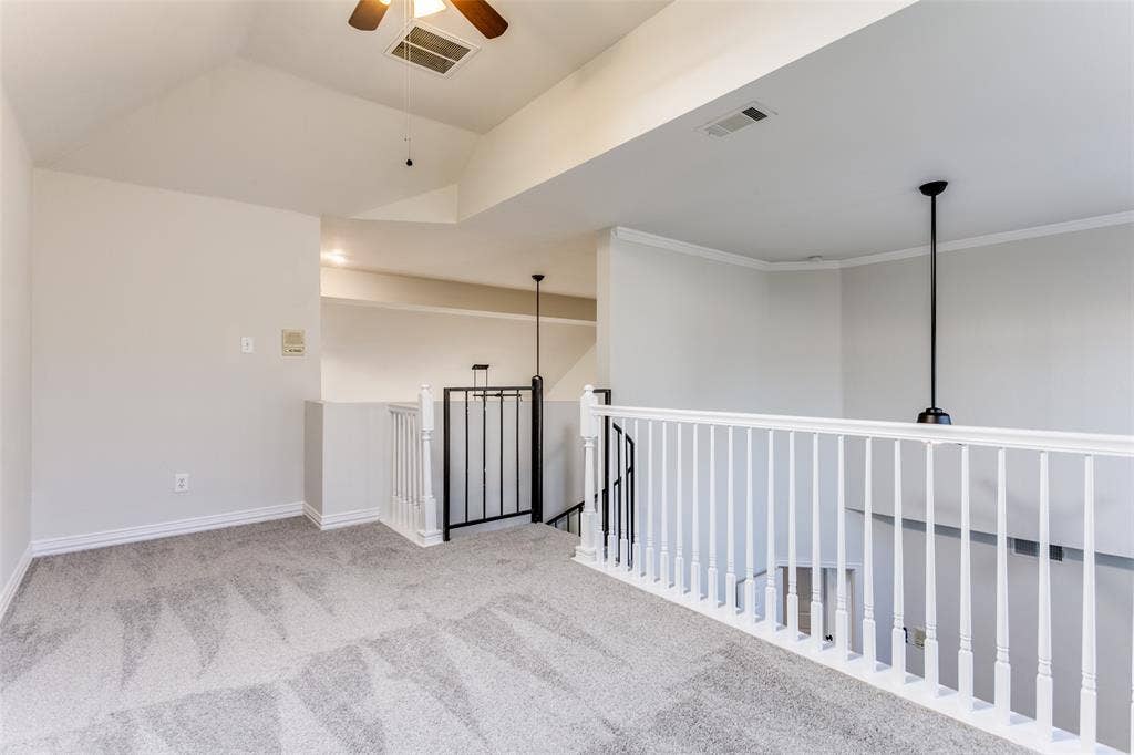 1214 Saint Regis Drive, Irving, TX 75038 Vaulted ceiling, carpeted flooring, and white railing featuring a metal accent panel
