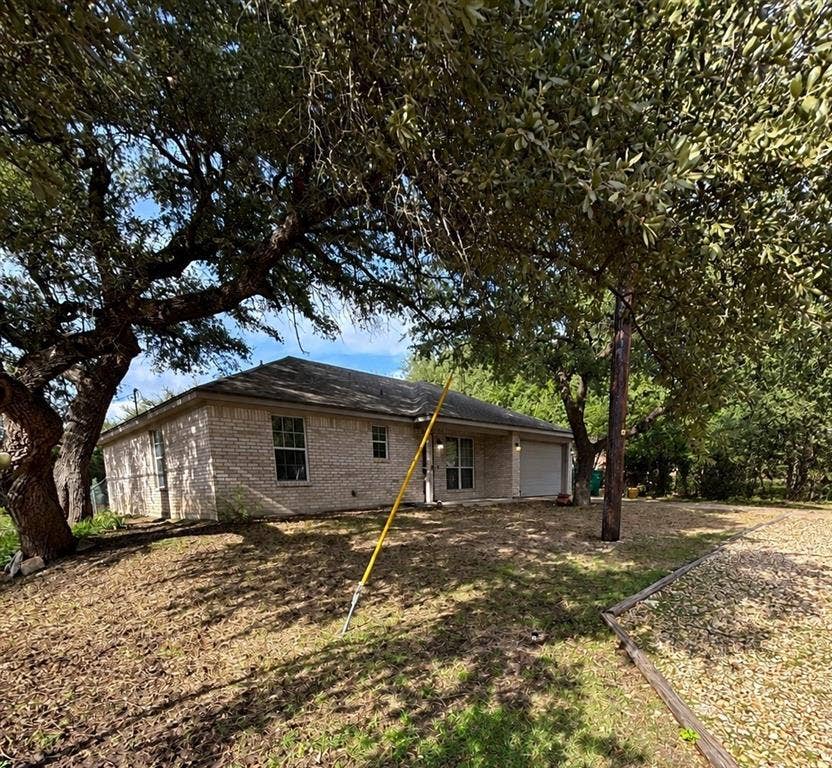 1 Mulberry Court, Morgans Point Resort, TX 76513 Single-story masonry exterior with a hip roof, multi-car garage, and mature trees on a lot with perimeter landscaping