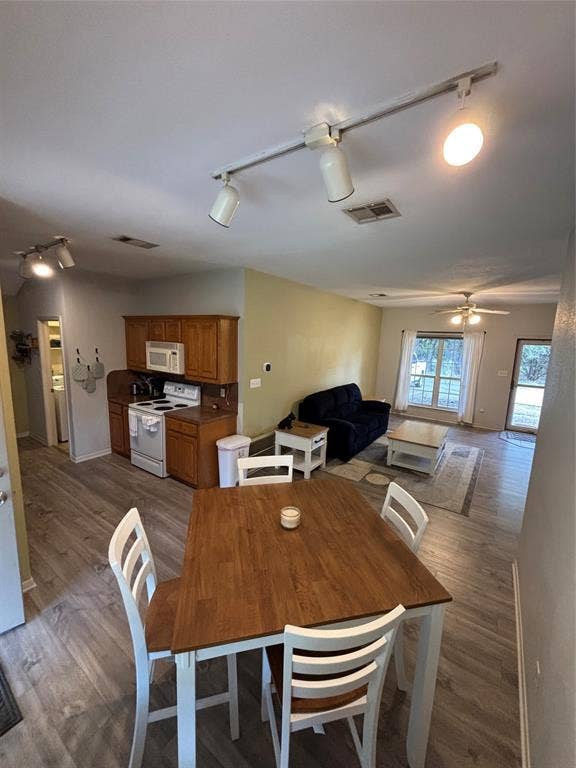 1 Mulberry Court, Morgans Point Resort, TX 76513 Open-concept interior featuring wood-finish flooring, track lighting, and a kitchen equipped with wood cabinetry and an over-the-range microwave