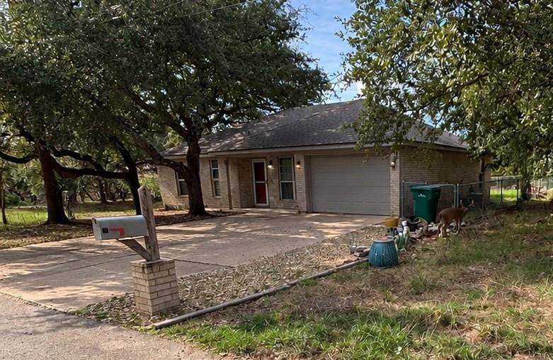 1 Mulberry Court, Morgans Point Resort, TX 76513 Single-story brick exterior featuring an attached two-car garage, concrete driveway, and established mature trees