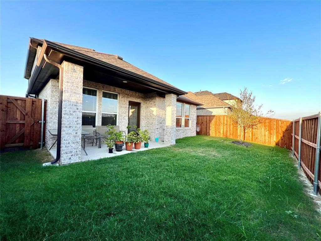 2707 Woodland Court, Wylie, TX 75098 Rear view of house featuring a lawn and a patio area