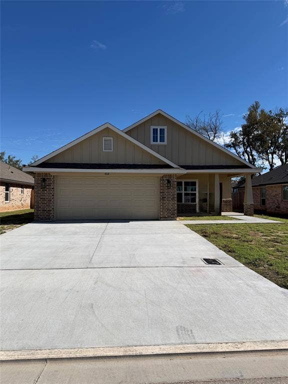 414 conway, Lacy Lakeview, TX 76705 Exterior featuring a gable roof, vertical siding, brick accents, and a concrete driveway