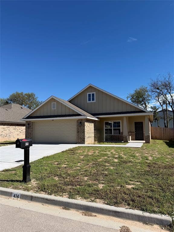 414 conway, Lacy Lakeview, TX 76705 Exterior facade featuring board-and-batten siding, brick accents, a two-car garage, and a covered front entryway