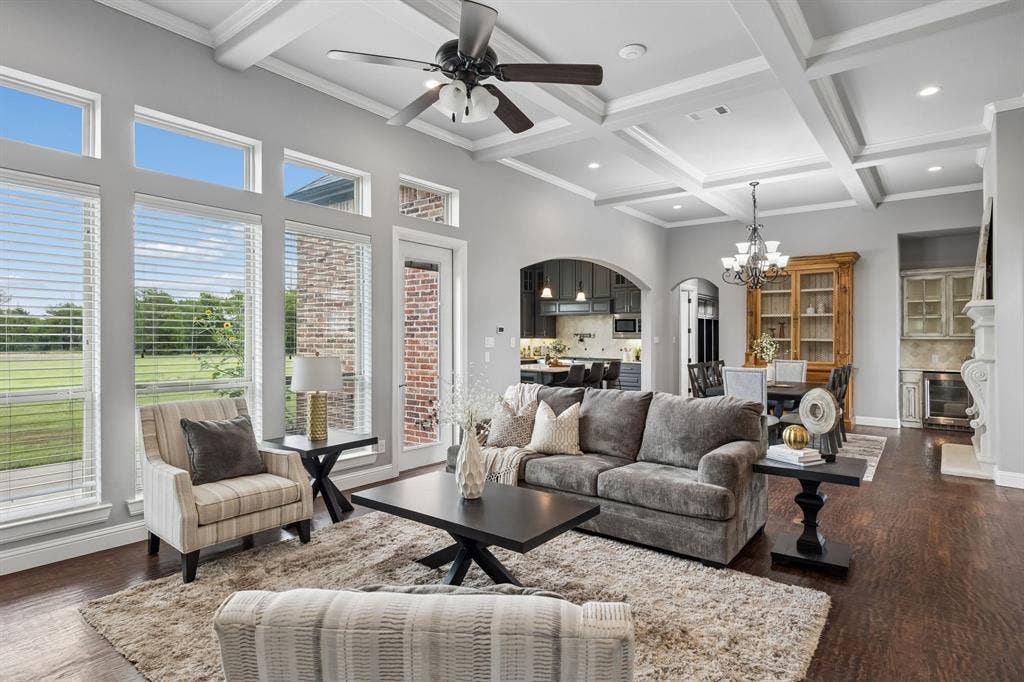 Coffered ceilings with recessed lighting, dark wood-finish flooring, floor-to-ceiling windows, and a built-in stone fireplace mantle