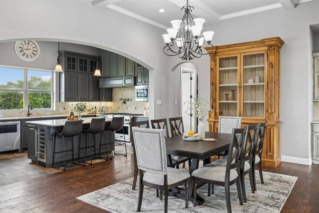 Kitchen featuring a large central island, dark-toned cabinetry, and wood-finish flooring