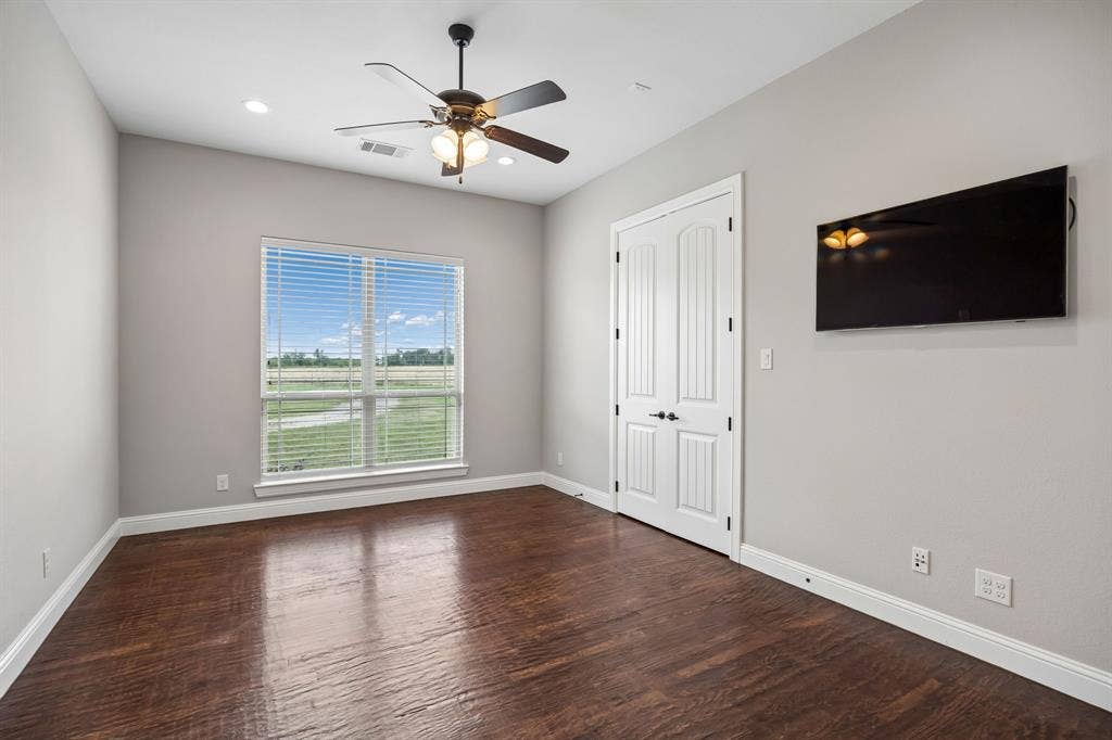 Room featuring wood-finish flooring, a ceiling fan with integrated lighting, recessed lighting, and double doors