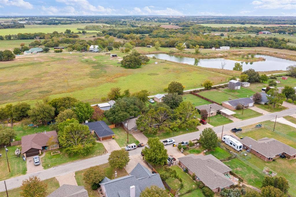 4043 Country Meadows Circle, Granbury, TX 76049 Aerial perspective of a sprawling landscape featuring expansive green acreage, mature trees, and a natural pond