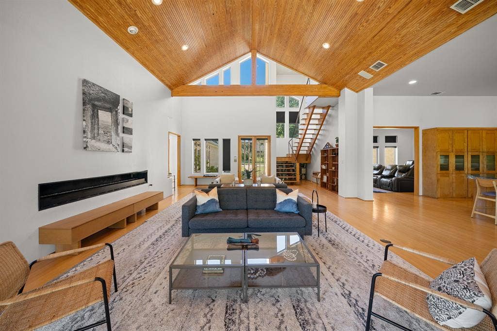 1997 Hollystone Drive, Tyler, TX 75703 Vaulted wood-plank ceiling, horizontal linear fireplace, wood-finish flooring, built-in cabinetry, and open staircase with wood steps