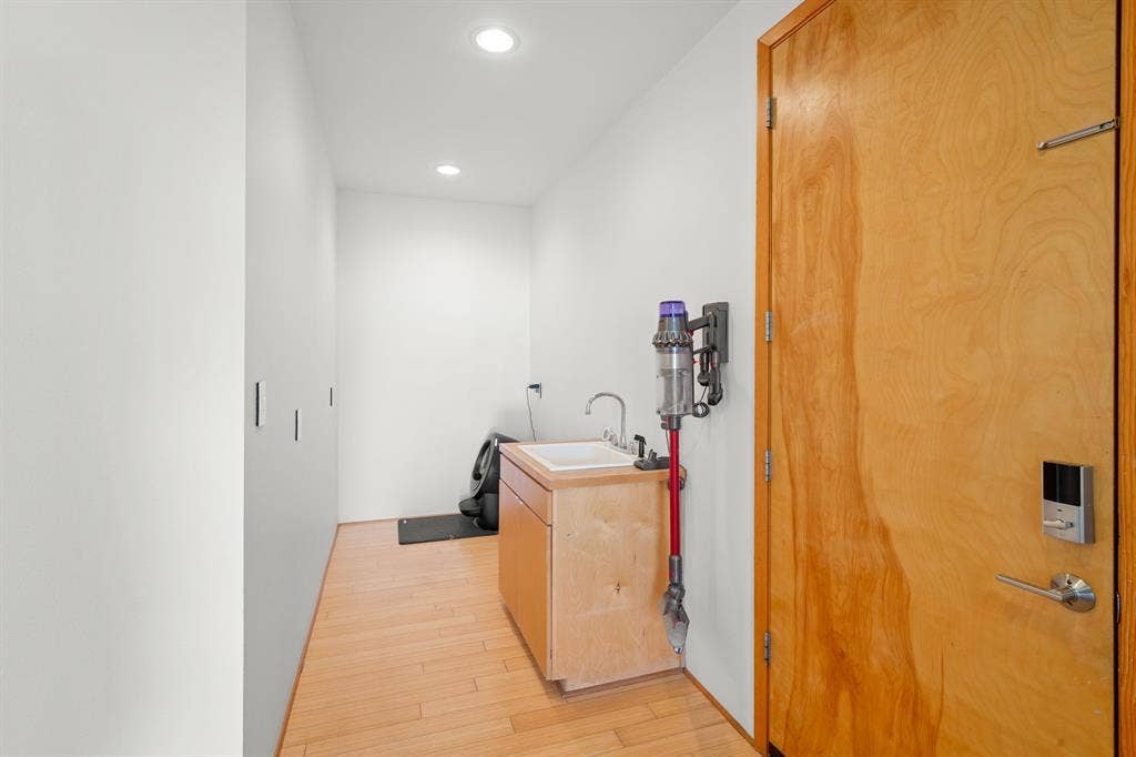 1997 Hollystone Drive, Tyler, TX 75703 Utility area featuring wood-finish flooring, recessed lighting, a wood-cabinet vanity with a rectangular sink, and a solid wood door with integrated electronic lock hardware