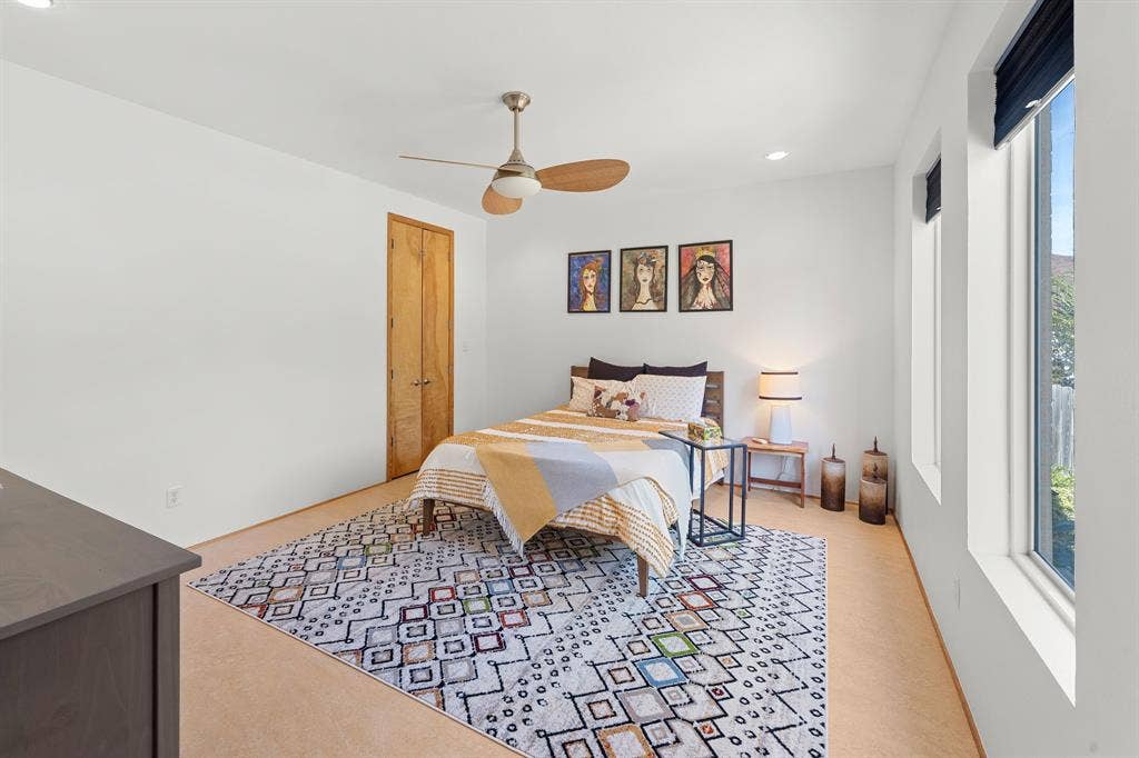 1997 Hollystone Drive, Tyler, TX 75703 Neutral-toned room featuring a minimalist ceiling fan with an integrated light fixture, clean-finish wood interior door, and tall vertical windows