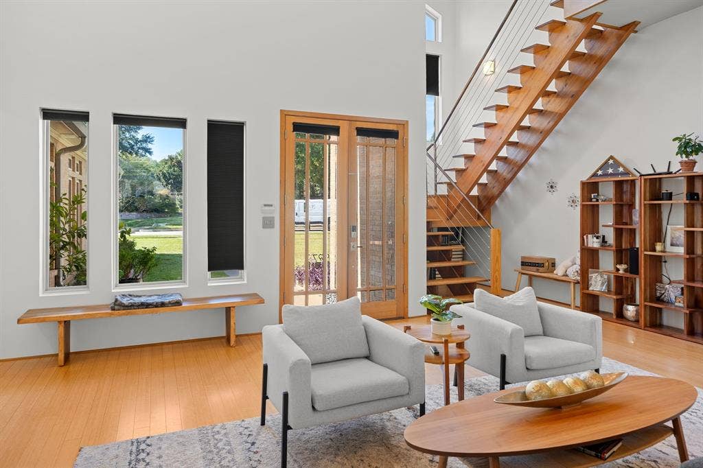 1997 Hollystone Drive, Tyler, TX 75703 Double-height living area featuring an open-riser staircase with metal cable railing, floor-to-ceiling windows, and wood-finish flooring