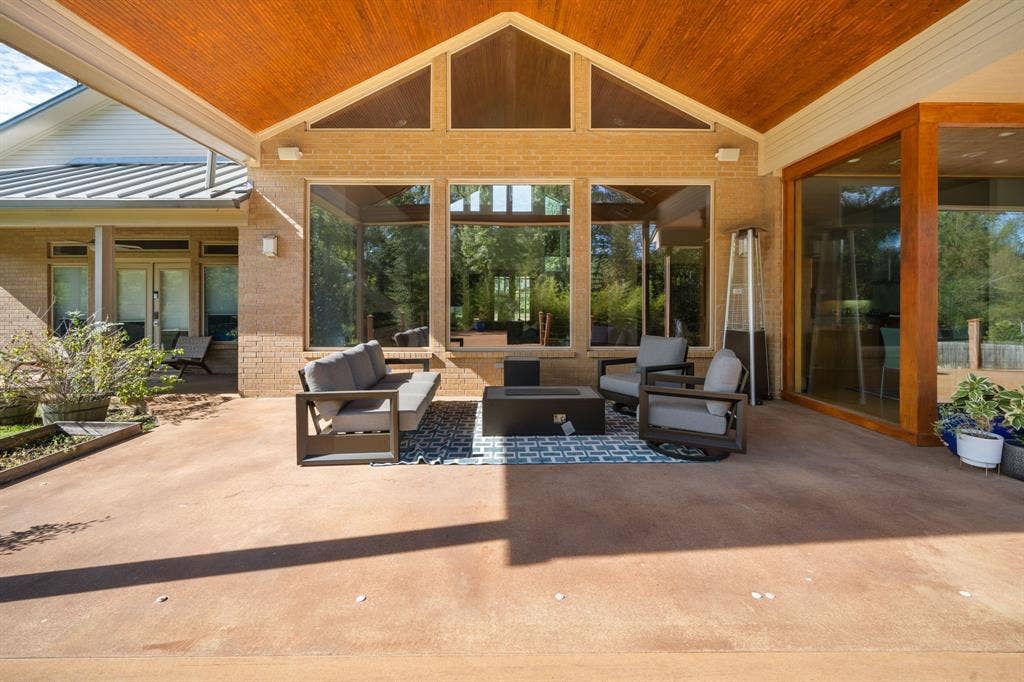1997 Hollystone Drive, Tyler, TX 75703 Covered outdoor patio featuring a vaulted tongue-and-groove wood ceiling, large picture windows, recessed lighting, and brick exterior walls