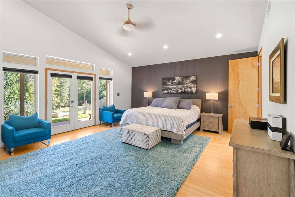 1997 Hollystone Drive, Tyler, TX 75703 Vaulted ceilings featuring recessed lighting, a ceiling fan, wood-finish flooring, a full-height accent wall, and glass-paneled double doors with transom windows