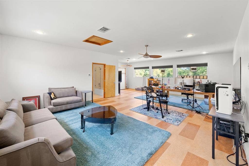 1997 Hollystone Drive, Tyler, TX 75703 Spacious room featuring resilient tile flooring, recessed lighting, a ceiling fan with integrated light, and large horizontal windows