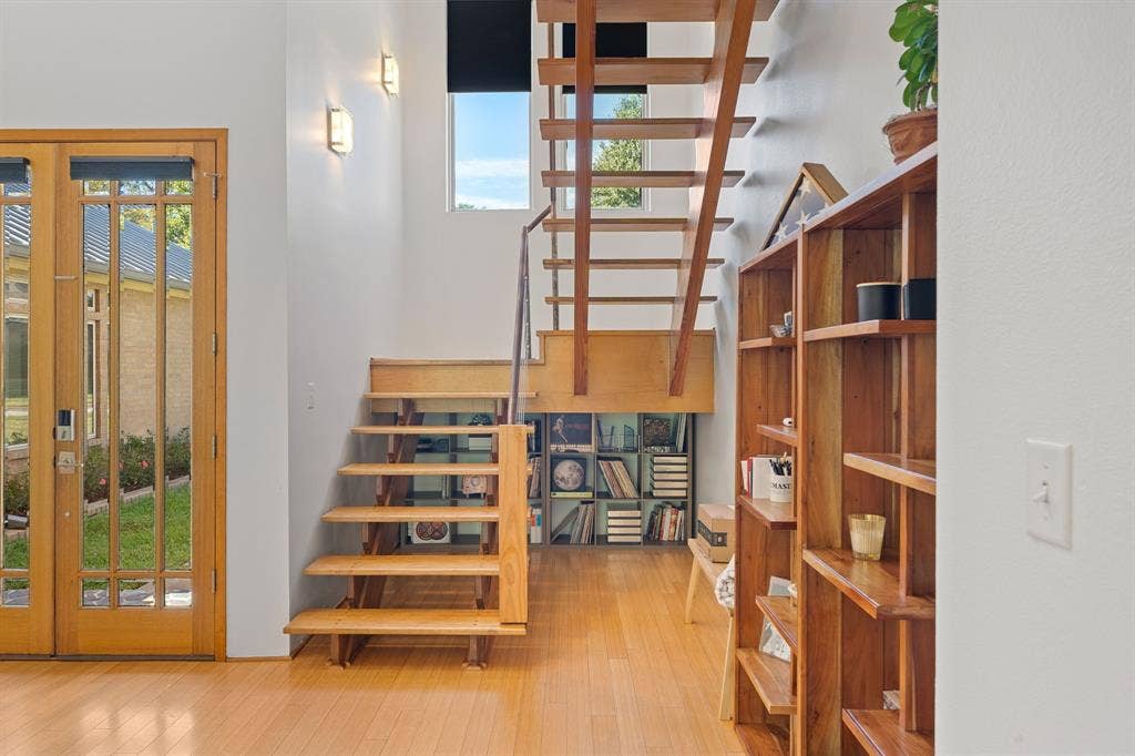 1997 Hollystone Drive, Tyler, TX 75703 Open-tread staircase with wood finish, integrated cube shelving, wood-finish flooring, multi-pane glass entry door, and vertical window configuration