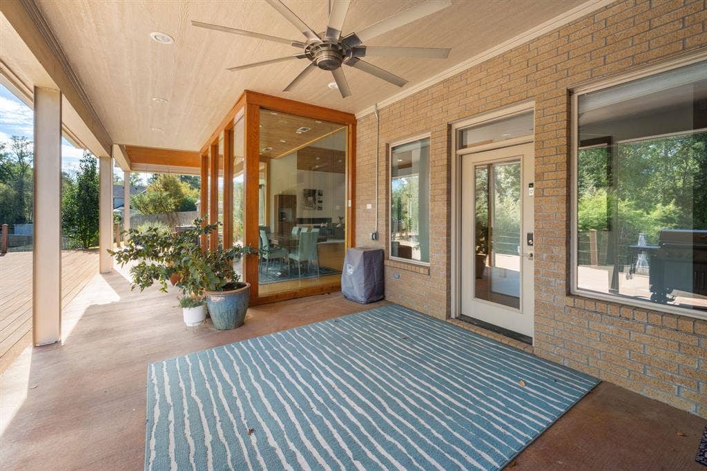 1997 Hollystone Drive, Tyler, TX 75703 Covered patio featuring a brick exterior, tongue-and-groove ceiling, industrial-style ceiling fan, and large glass paneled door