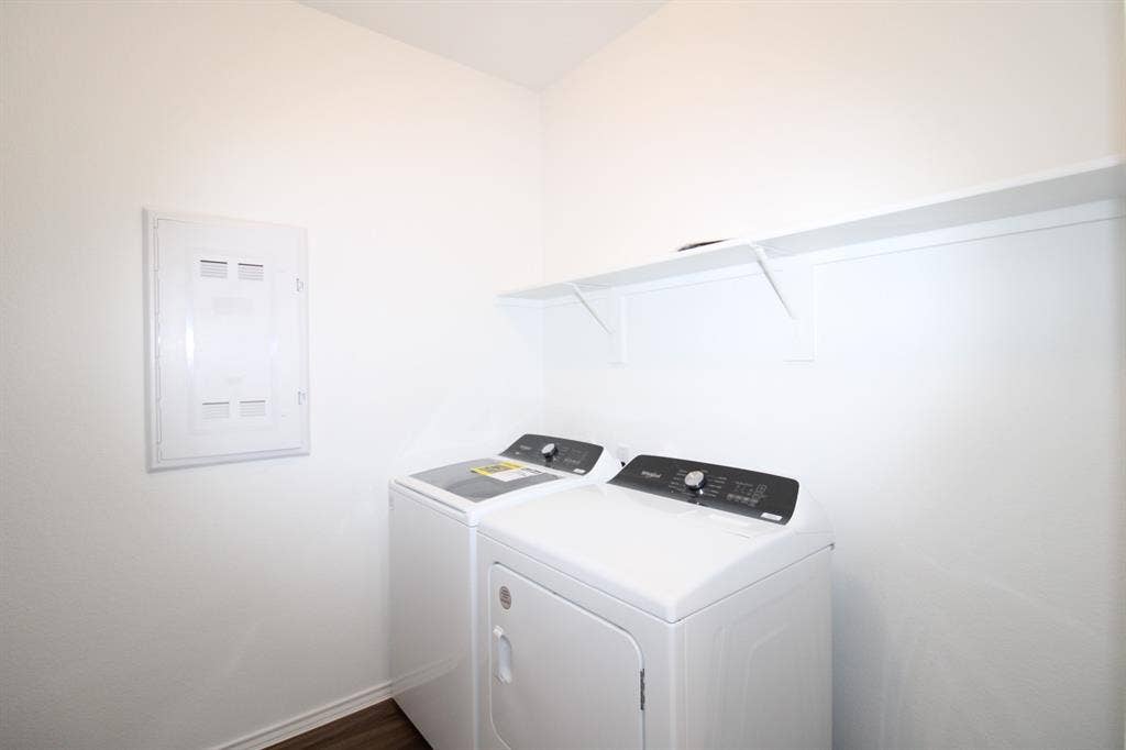 Dedicated laundry area featuring a wall-mounted shelving unit and an integrated electrical panel
