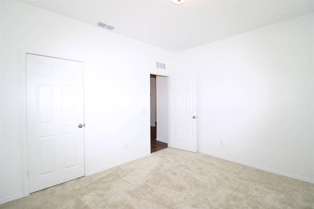 Neutral-toned wall-to-wall carpeting, white six-panel interior doors, and ceiling-mounted light fixture
