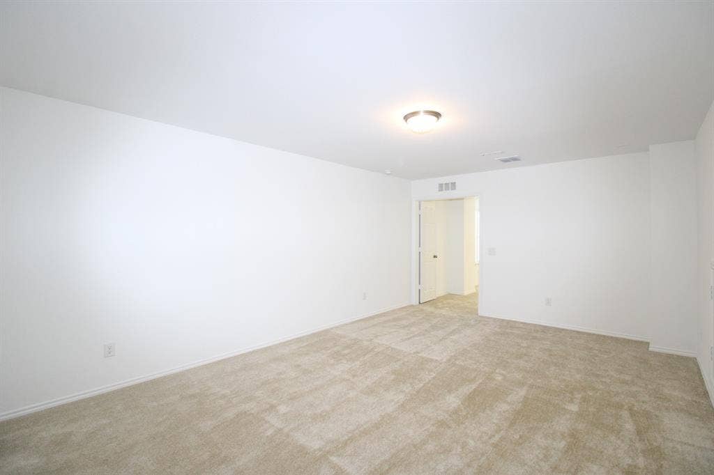 Interior space featuring neutral wall tones, wall-to-wall carpeting, and a flush-mount ceiling light fixture
