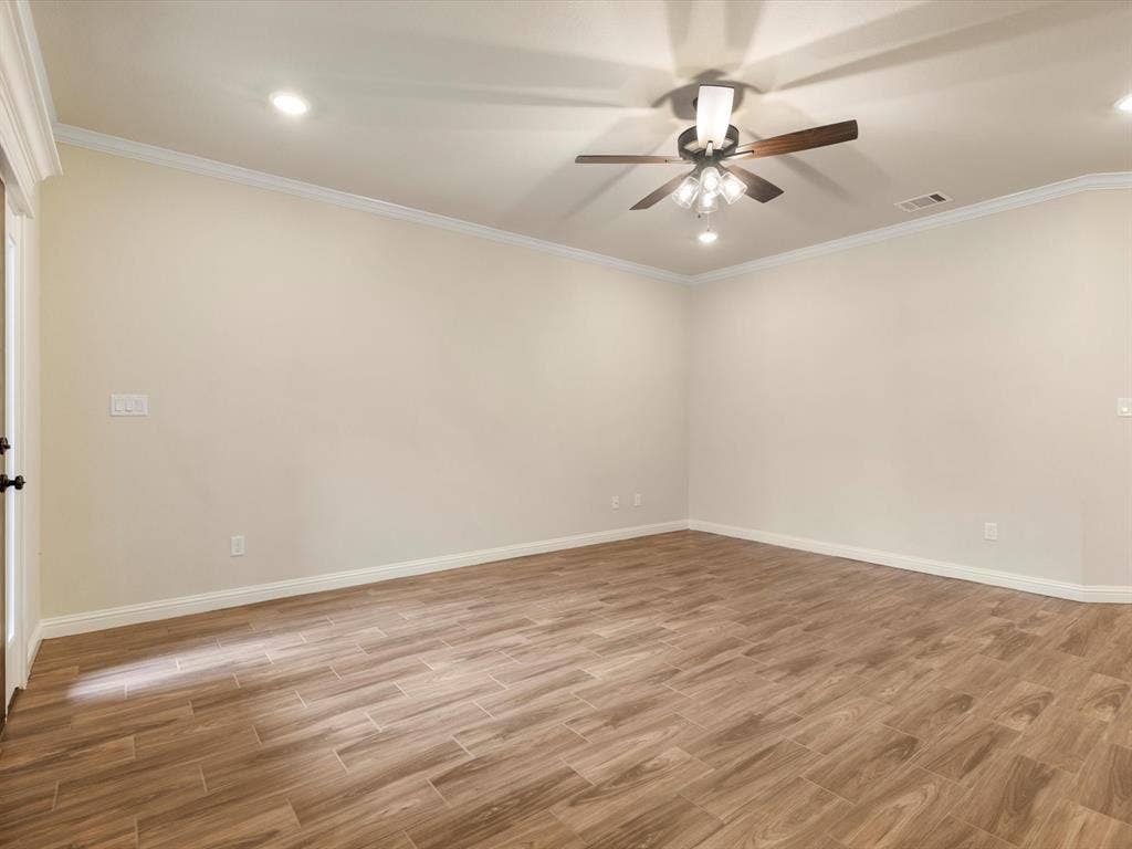 Room featuring wood-finish tile flooring, crown molding, recessed lighting, and a ceiling fan with integrated light fixture