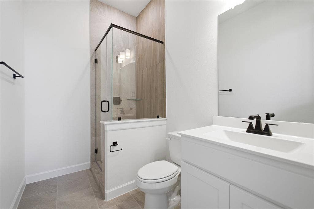 Contemporary bathroom featuring a glass-enclosed shower with tiled walls and a built-in shelf