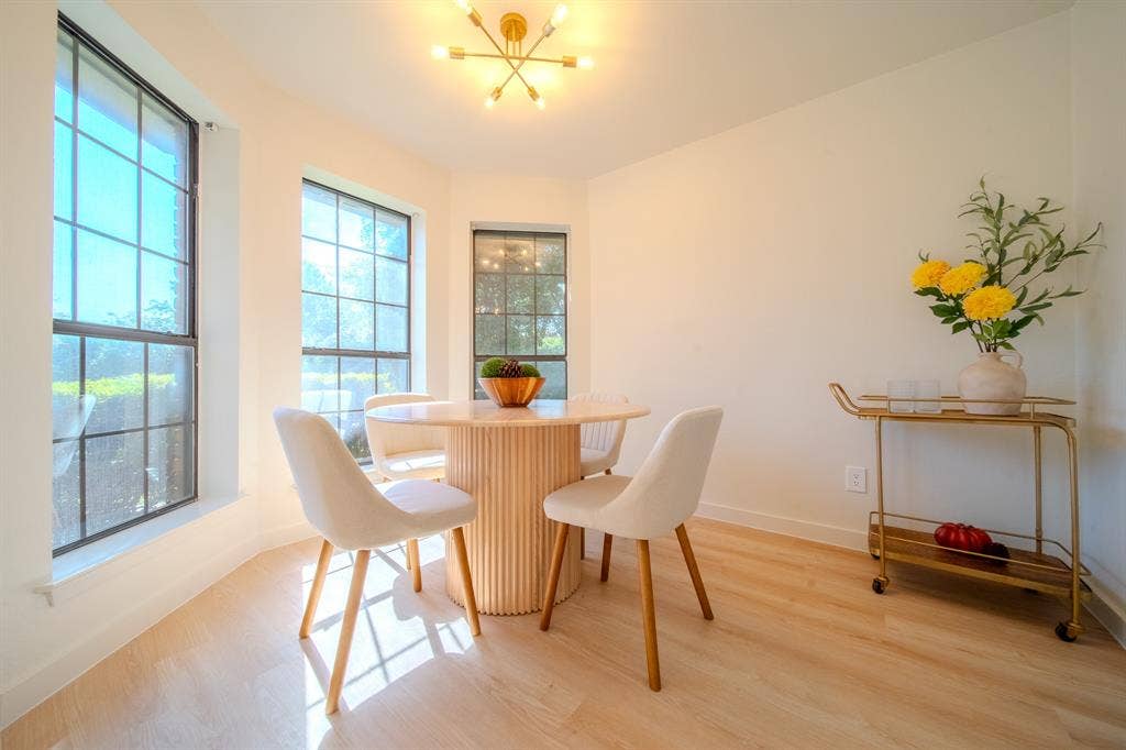 2213 Moore Drive, Plano, TX 75074 Sun-filled alcove featuring large windows, wood-finish flooring, and a modern multi-arm light fixture